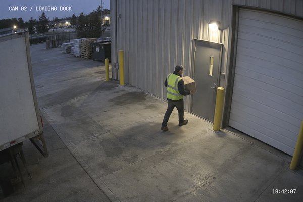Sample camera snapshot: a delivery worker carrying a box at a warehouse loading dock.